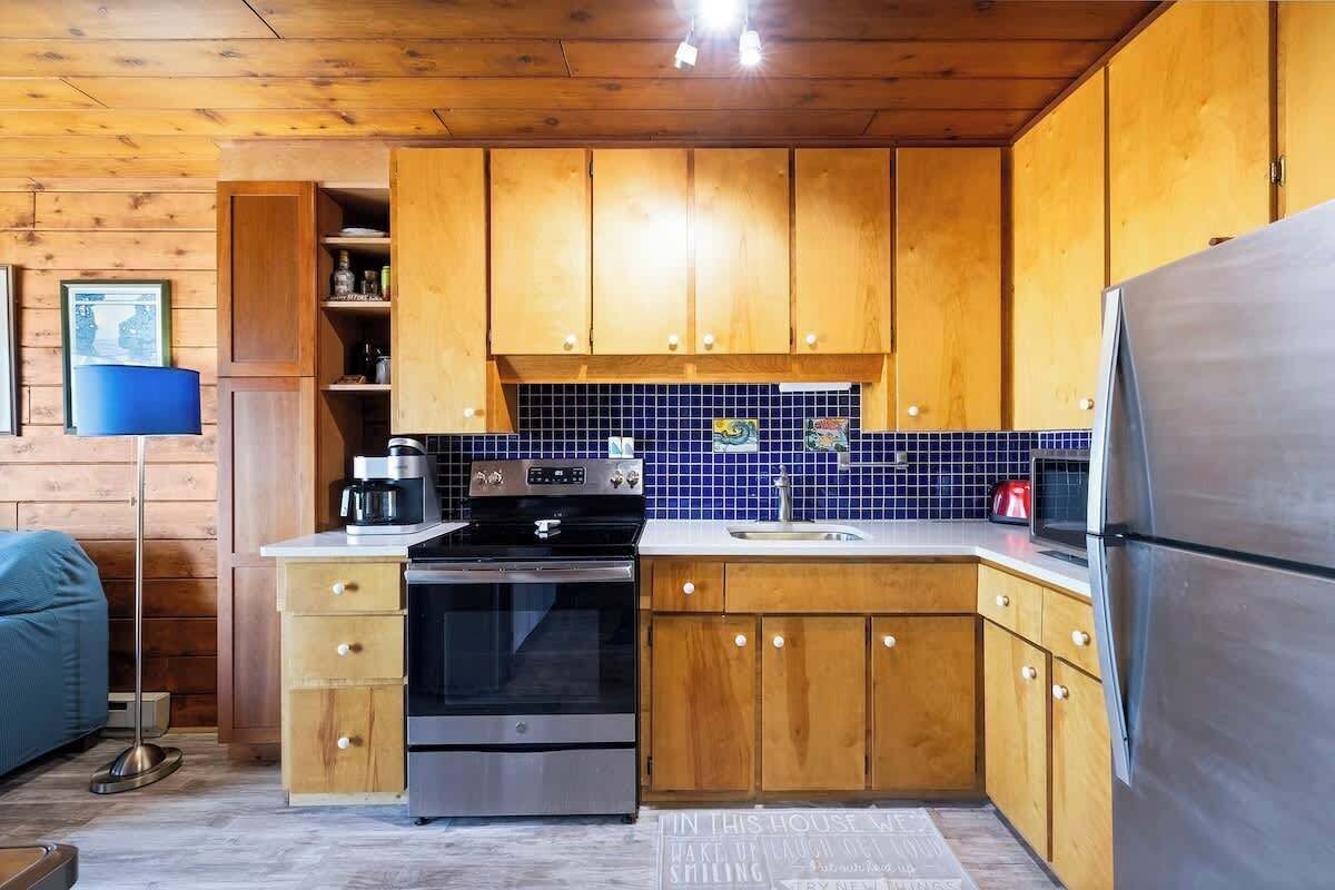 A kitchen with wooden cabinets, a stainless steel refrigerator, a microwave, and a coffee maker.