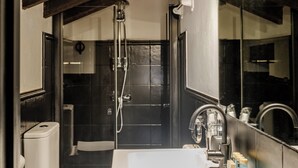 A modern bathroom with a white sink, a mirror, and a shower.