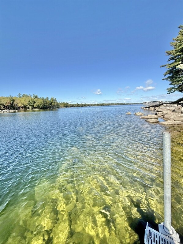 Un lac aux eaux limpides, avec un quai et une jetée qui s’avancent dans l’eau.