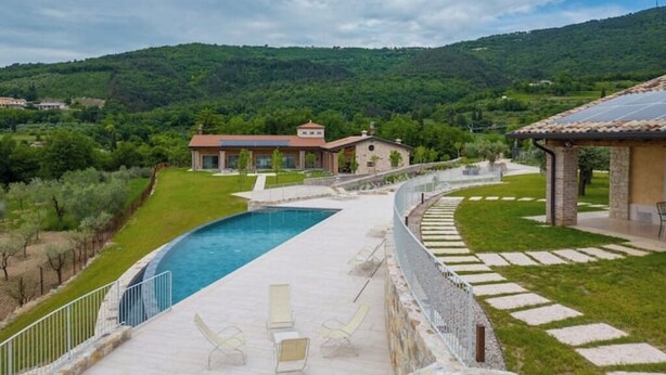 A swimming pool with lounge chairs, a stone pathway, and a view of a hillside. - L'Oro di Pizzon - Frantoio | Pool & Garden (Pizzon)