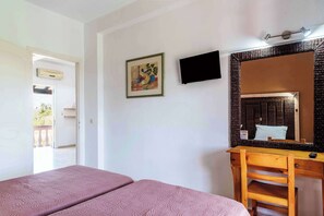 A room with a bed, a desk, a mirror, and a painting on the wall. - Pink House Socrates Corfu Beachside Apartments (Gardenos)