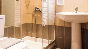 A bathroom with a glass-enclosed shower, a white sink, and a toilet. - Pink House Socrates Corfu Beachside Studio (Gardenos)