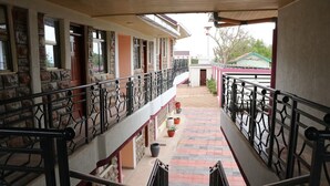 A multi-level building with balconies, stone walls, and potted plants. - The Haven Luxury Guest House moyale (Moyale)