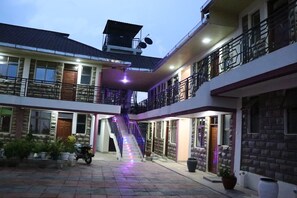 A multi-story building with a central staircase, balconies, and a paved courtyard. - The Haven Luxury Guest House moyale (Moyale)