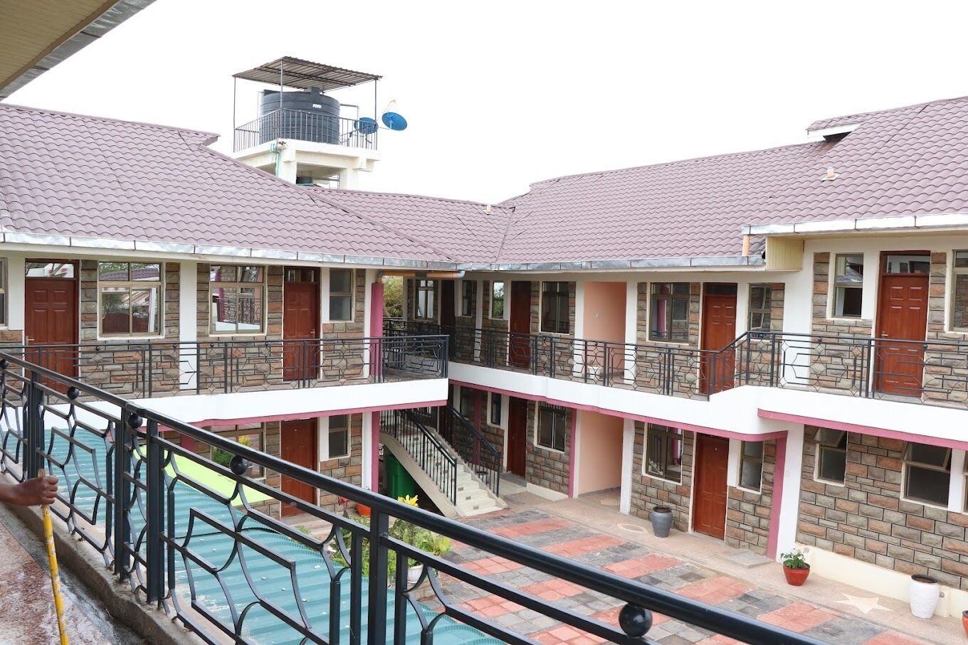 A multi-story building with a central courtyard, balconies, and a swimming pool.