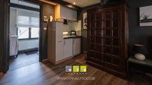 A modern kitchen with a built-in oven, microwave, and a wooden cabinet. - Studio: Stefan Evers Mid long term rentable (Maaseik)