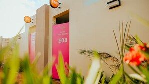Un edificio moderno con una puerta rosa marcada con 