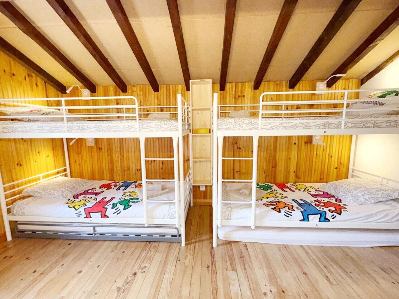 Ein Zimmer mit zwei Etagenbetten, Holzwänden und Holzboden.