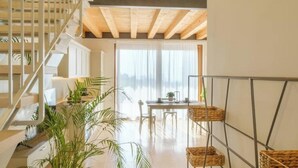A modern interior with a staircase, a dining area, and wicker baskets on a metal stand. - L´Oro di Pizzon - Frantoio Deluxe | Panoramic View (Pizzon)