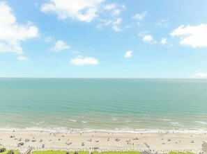 Une plage avec un ciel dégagé et une mer calme.