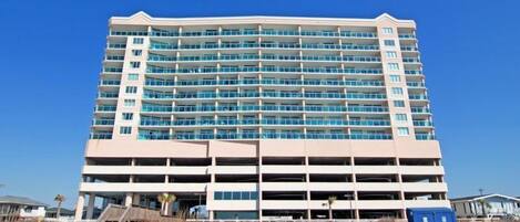 Un hôtel à plusieurs étages doté d’un parking central et situé en bord de mer.