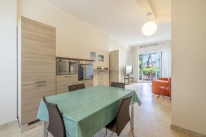 Una cocina moderna con comedor, televisor y vistas al exterior.
