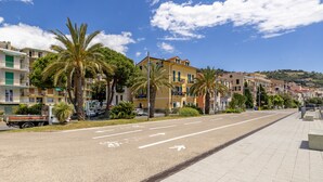 A wide, empty street with a clear blue sky and buildings on both sides. - Next to the Beach by Wonderful Italy (Ospedaletti)