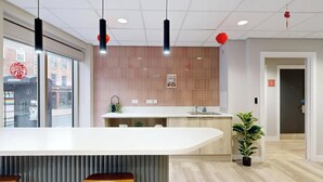 Une cuisine moderne dotée d’un îlot central, de tabourets de bar, d’un évier et d’une plante en pot.
