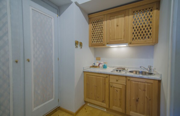 Eine Küche mit Holzausstattung, einem Spülbecken und einer Arbeitsfläche mit verschiedenen Gegenständen.
