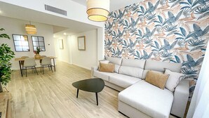 Un salon moderne comprenant un canapé, une table basse et un coin repas avec des chaises et une table.