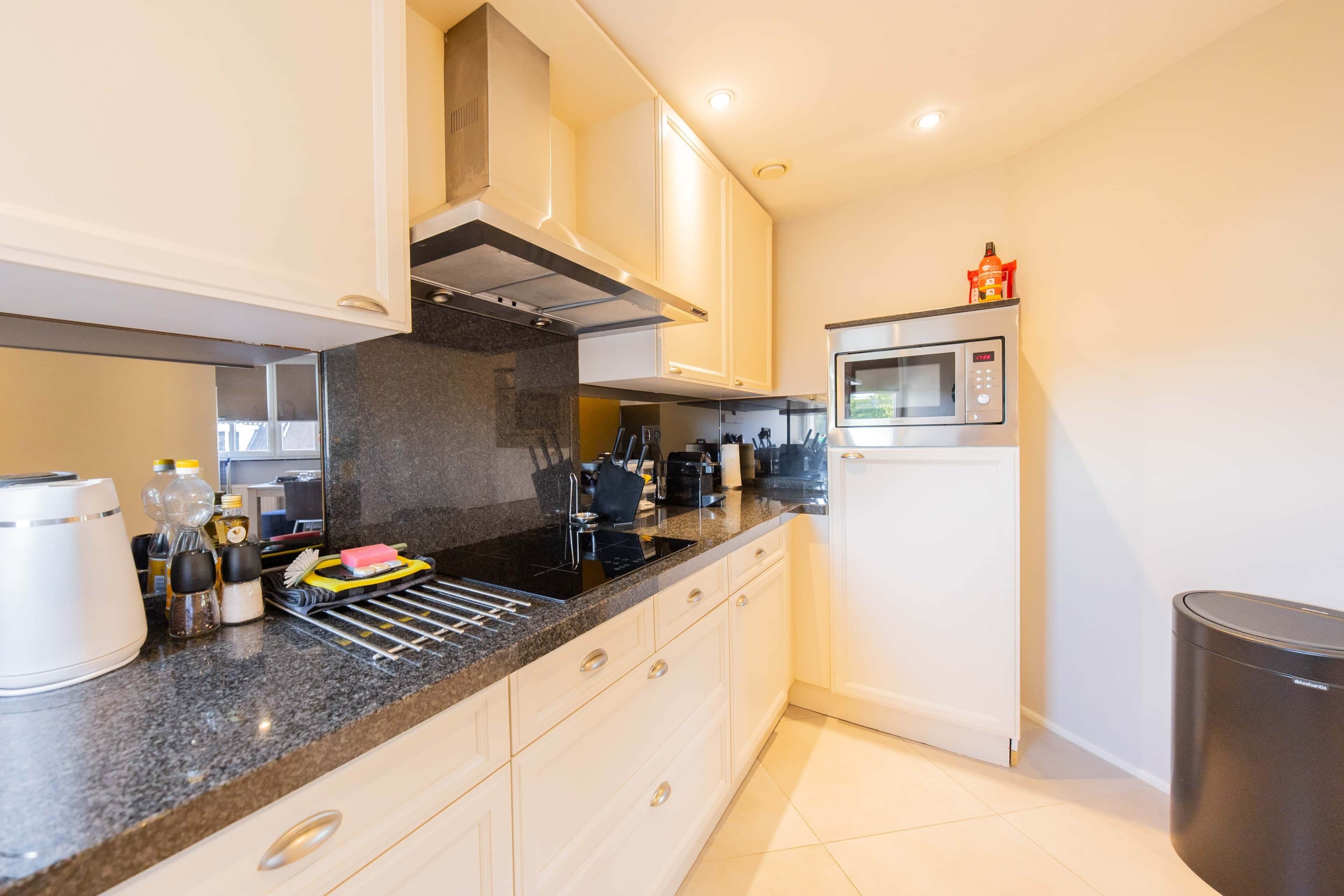 A modern kitchen with a microwave, stove, and various appliances.