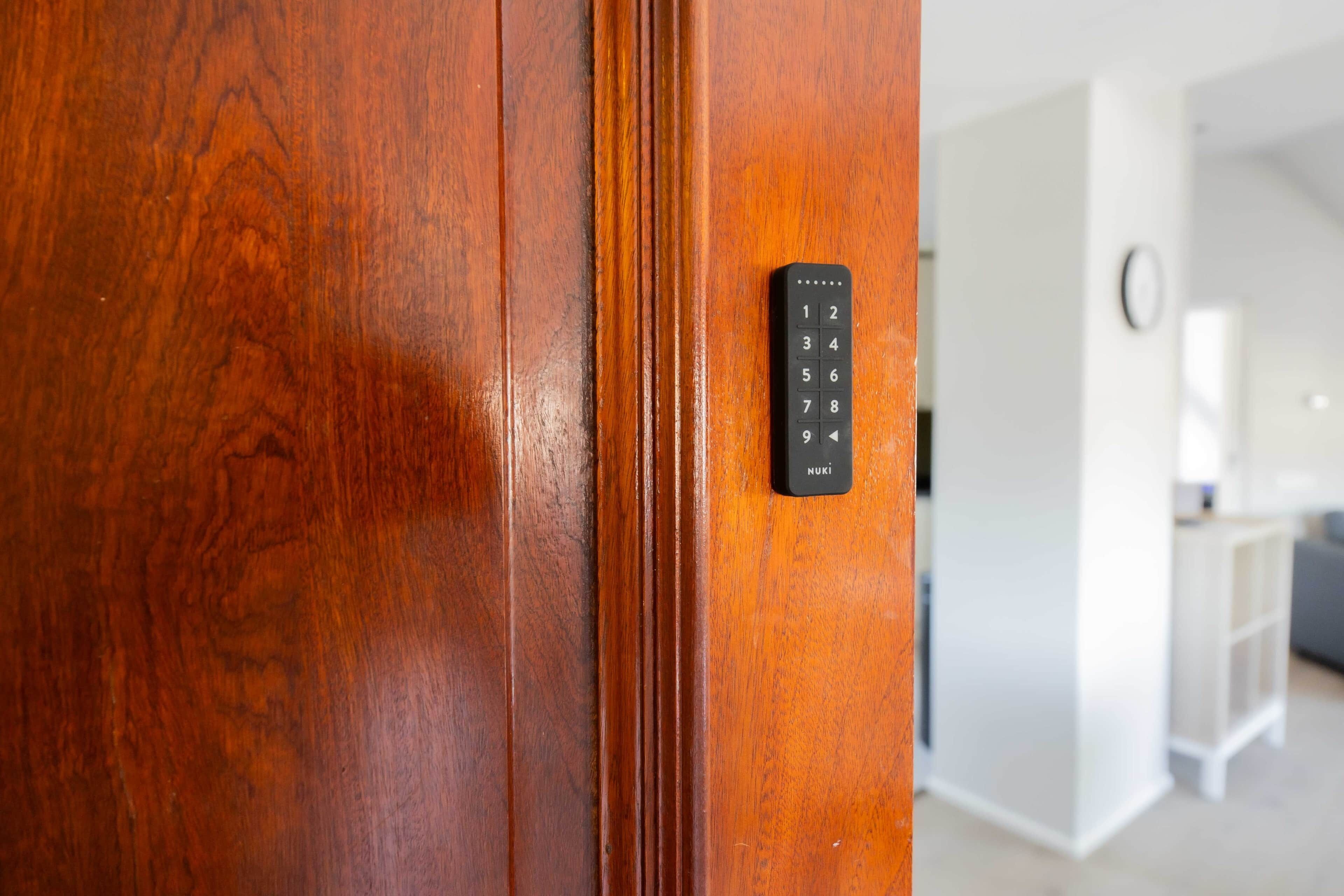 A wooden door with a black electronic keypad lock.