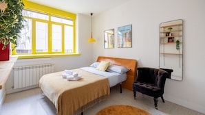 A bedroom with a bed, a chair, a radiator, a window, and a shelf. - Central Flat Next to Gran V a Work or Study (Madrid)