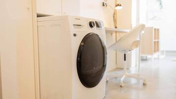 Een witte Samsung wasmachine in een lichte, moderne wasruimte met een minimalistisch design.
