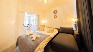 Una habitación de hotel con cama, sofá, escritorio y una silla.