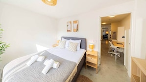 Une chambre d’hôtel comprenant un lit, des tables de chevet, un bureau et une chaise.