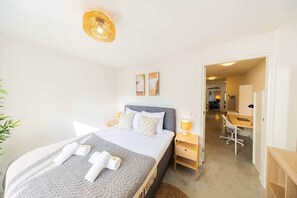 Une chambre d’hôtel comprenant un lit, des tables de chevet, un bureau et une chaise.