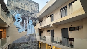 A multi-story building with a mural on the exterior wall. - GoBravo Residences – Kapashera, New Delhi (New Delhi)