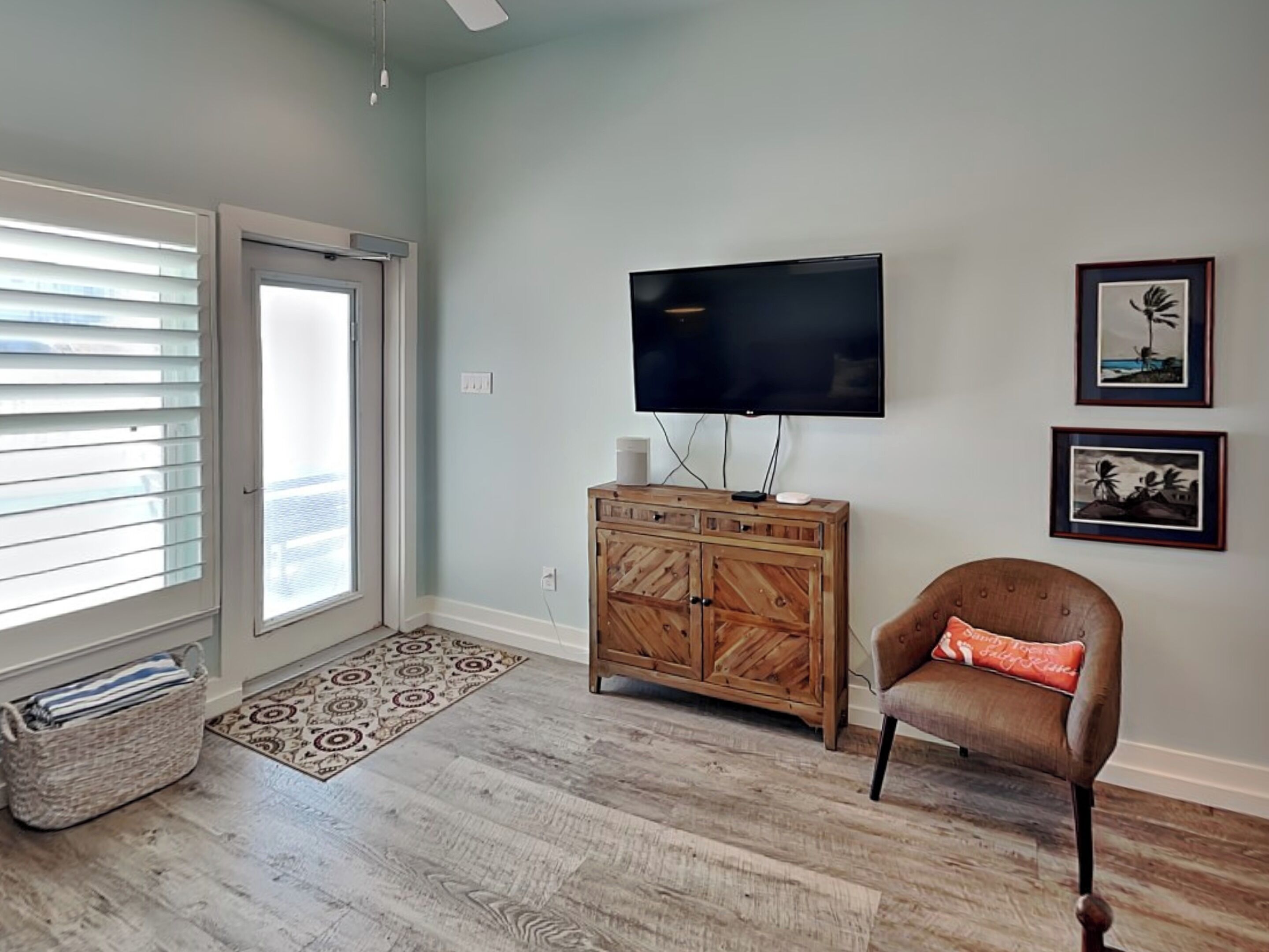 A living room with a wooden cabinet, a television, and a chair.