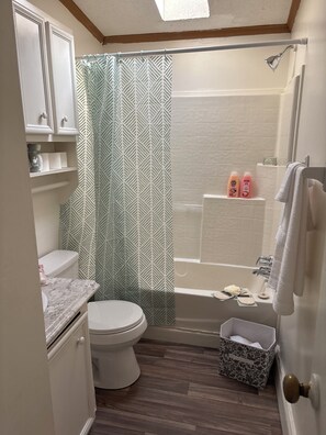 Een douche, handdoeken, zeep, toiletpapier