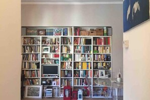 A room with a large bookshelf filled with books and various items. - Charming Apartment on the Navigli (Milano)