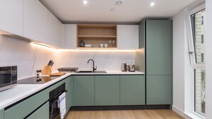 Eine moderne Küche mit integriertem Mikrowellenherd, Spüle und einer Holz Arbeitsplatte.