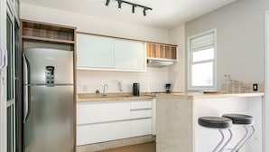 Een koelkast, een magnetron, een oven, kookgerei, borden en bestek