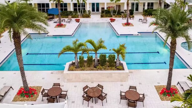 A hotel with a central swimming pool surrounded by palm trees and outdoor seating areas. - Downtown Skyline Suite- Breathtaking view (Fort Myers)