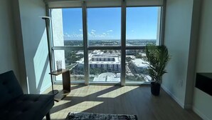 A spacious room with a large window offering a city view. - Downtown Skyline Suite- Breathtaking view (Fort Myers)
