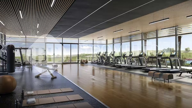 A modern gym with exercise equipment, large windows, and a wooden floor. - 224-Bloomfields Modern Stu Yas Golf  (Abu Dhabi)