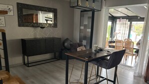 A modern dining area with a wooden table and black chairs, a black console, and a large mirror on the wall. - Charming villa for a vacation in the south of France (Uzès)