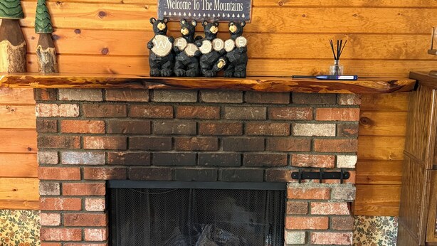 A fireplace with a brick surround and a wooden mantel. - Goldilocks Mountain Vibes for All Your Bears - No Better than Our Relaxing Mountain Vibes Cabin, 3BR for Mamma, Papa, and Baby Bears! (Big Bear)