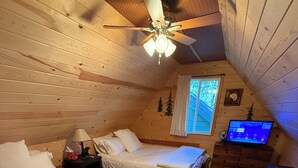 A cozy cabin bedroom with two beds, a ceiling fan, a TV, and a window with curtains. - Goldilocks Mountain Vibes for All Your Bears - No Better than Our Relaxing Mountain Vibes Cabin, 3BR for Mamma, Papa, and Baby Bears! (Big Bear)