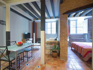 Una cucina moderna con zona pranzo, TV e un'ampia finestra.