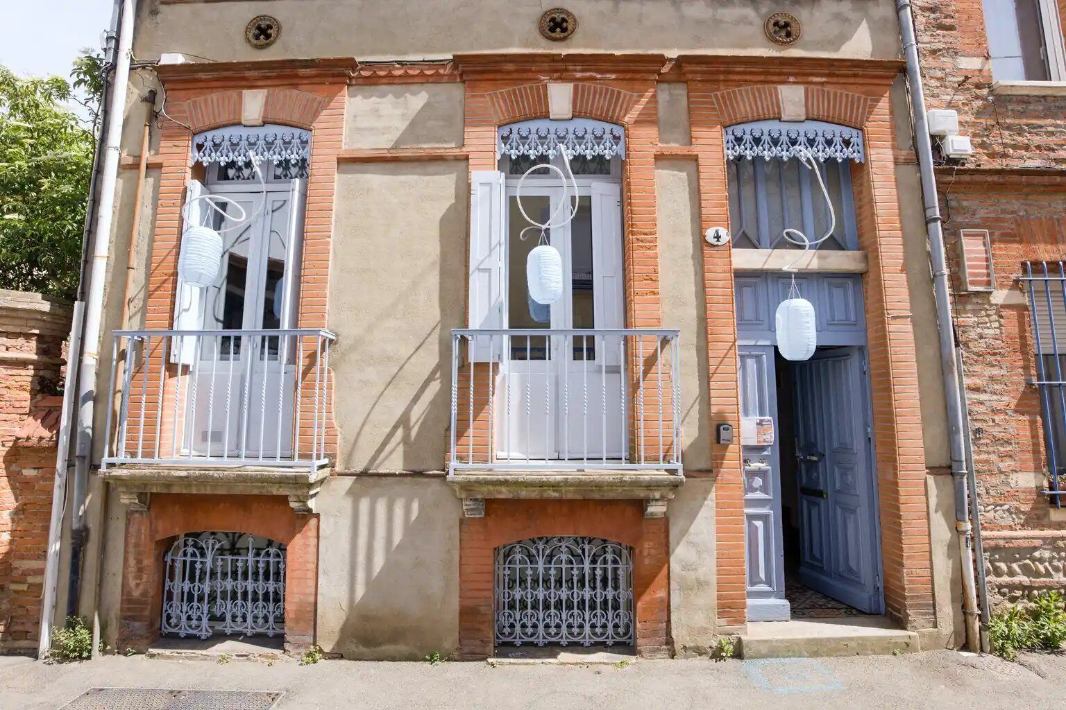 A building with three windows, each with a balcony and decorative ironwork.