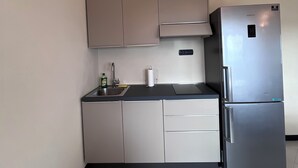 A compact kitchen with a stainless steel refrigerator, a built-in oven, and a sink. - Collimare rooms (Vezzano Ligure)