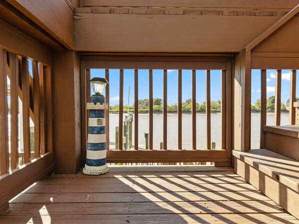 Une terrasse en bois offrant une vue sur une rivière et une végétation luxuriante en arrière-plan.