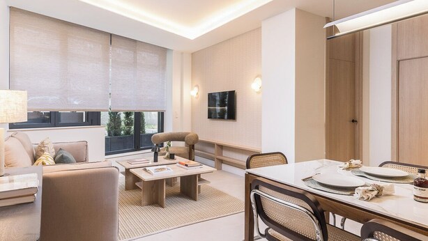 Ein modernes Wohnzimmer mit Sofa, Couchtisch und Esstisch.