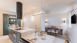 A modern kitchen with a marble countertop, integrated oven, and a dining area with a table and chairs. - Ramón de Santillán II (Madrid)