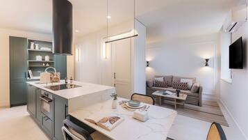 Een moderne keuken met een marmeren aanrecht, een ingebouwde oven en een eethoek met een tafel en stoelen.
