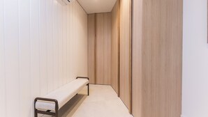 A hallway with a bench, wooden panel walls, and a tiled floor. - Ramón de Santillán II (Madrid)