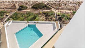 Une piscine sur le toit offrant une vue sur la plage et l’océan.