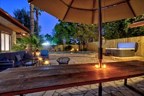 An outdoor patio area with a wooden table, chairs, a barbecue grill, and a pool. - San Antonio Resort Home | Pool, Hot Tub, Casita & Game Room (San Antonio)