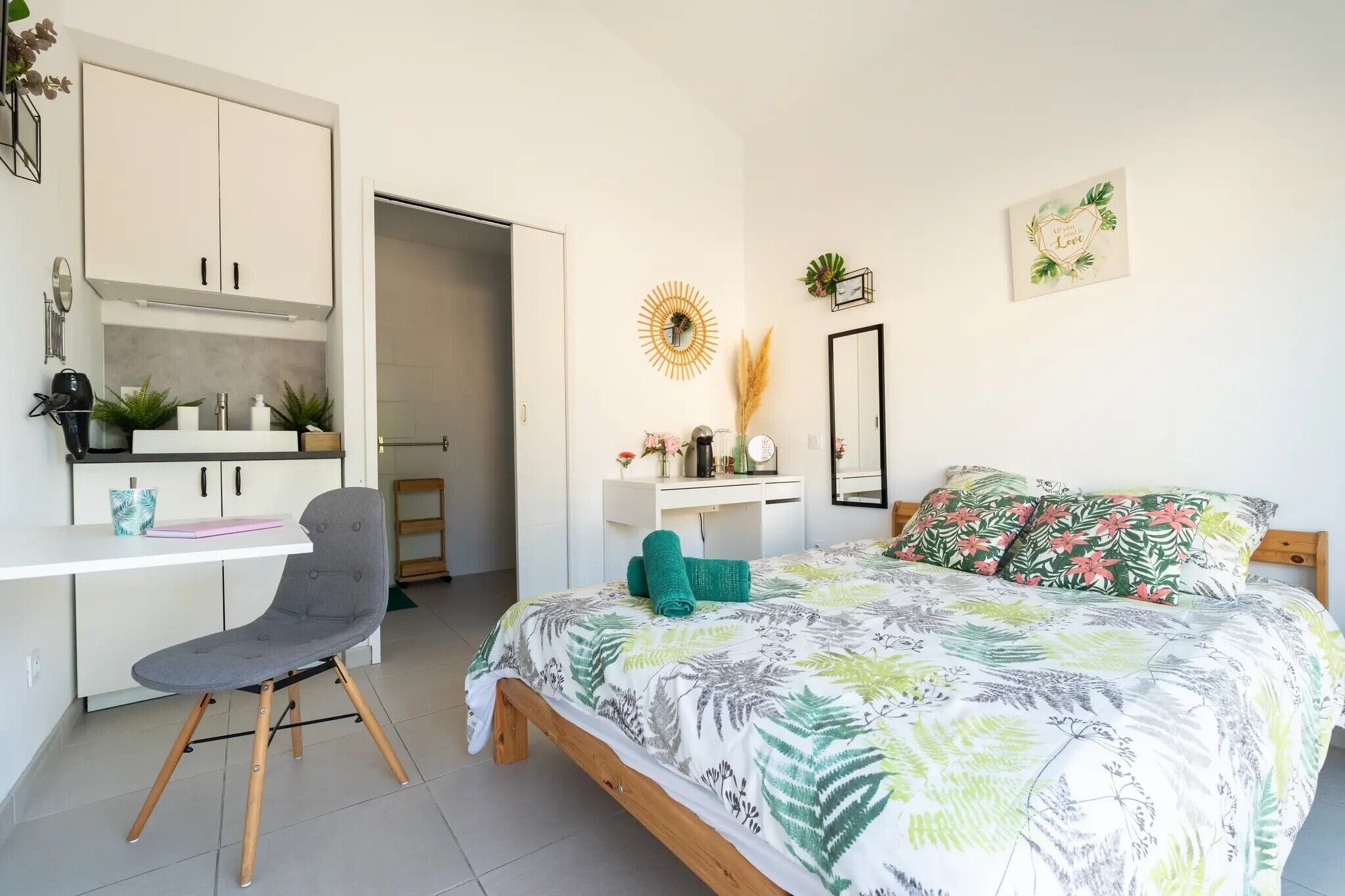 A bedroom with a bed, a desk, a chair, and a wardrobe.